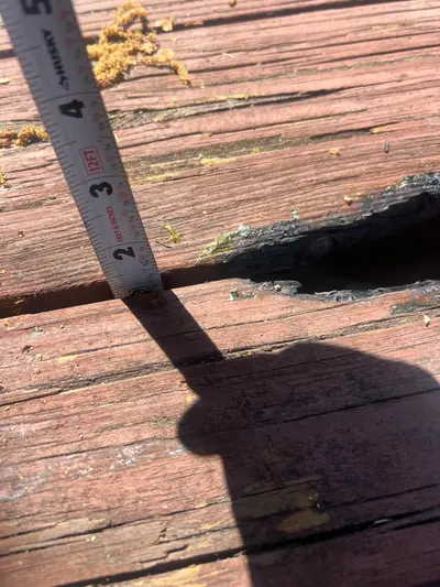 Measuring a damaged, rotted deck board for repair