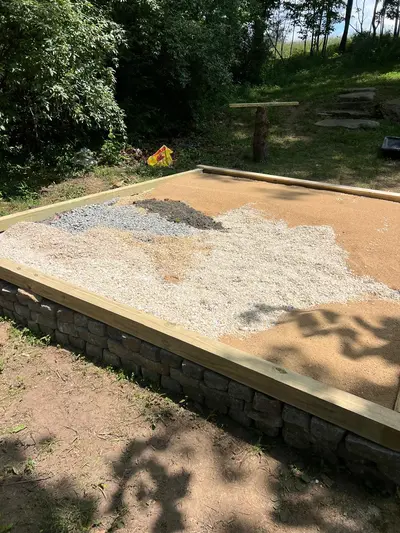 Gravel base being leveled inside the patio frame