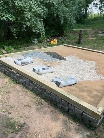 Bagged leveling sand staged on the gravel base